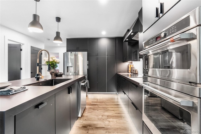9161 W Lake Dr, Littleton, CO 80123 - kitchen featuring appliances with stainless steel finishes, light wood-type flooring, pendant lighting, dark cabinets, and modern cabinets