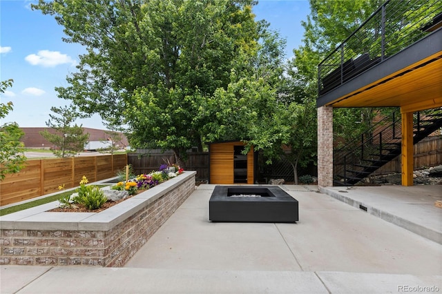 9161 W Lake Dr, Littleton, CO 80123 - fenced backyard with an outdoor fire pit, a patio area, stairs, and a storage unit