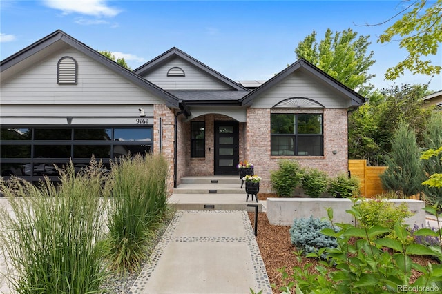 9161 W Lake Dr, Littleton, CO 80123 - view of front of house featuring solar panels, brick siding, and an attached garage