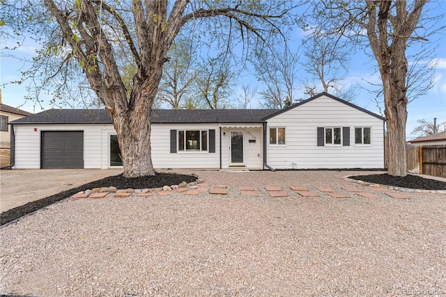 ranch-style home with an attached garage, fence, and driveway