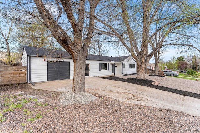 ranch-style house with concrete driveway, fence, and a garage