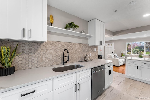 kitchen featuring dishwasher, open shelves, white cabinets, and a sink