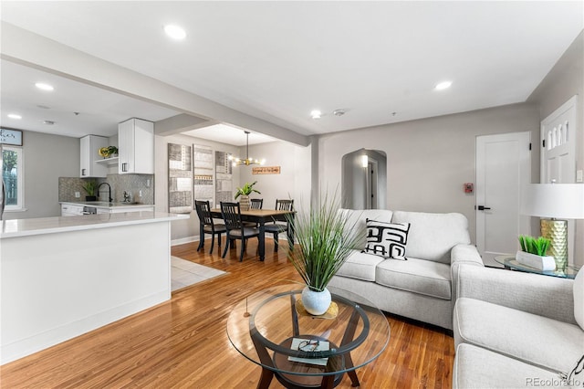 living room featuring recessed lighting, light wood-style floors, and an inviting chandelier