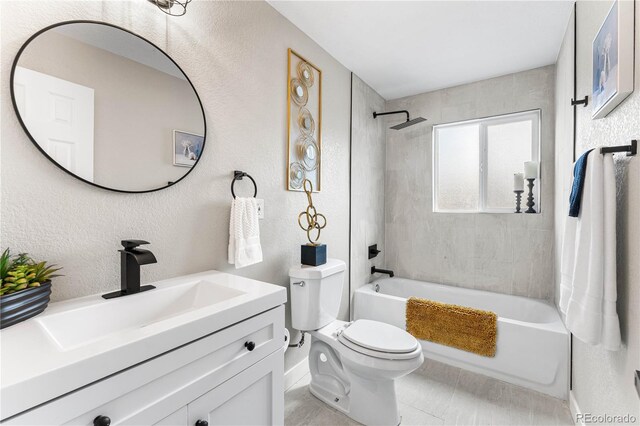 bathroom featuring tub / shower combination, toilet, vanity, and a textured wall