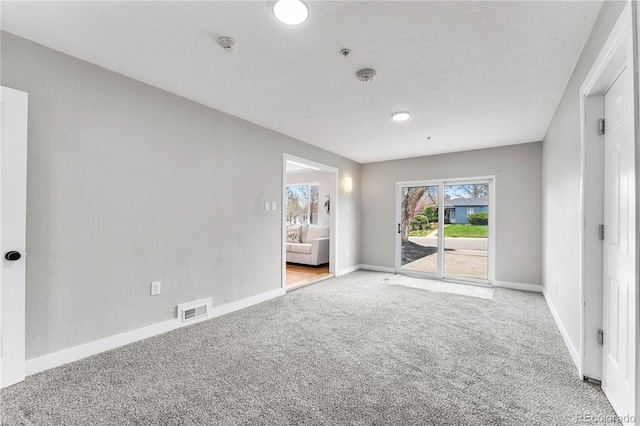 carpeted empty room with baseboards and visible vents