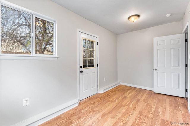 interior space with baseboards and light wood finished floors