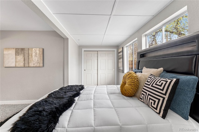 bedroom featuring a paneled ceiling and a closet