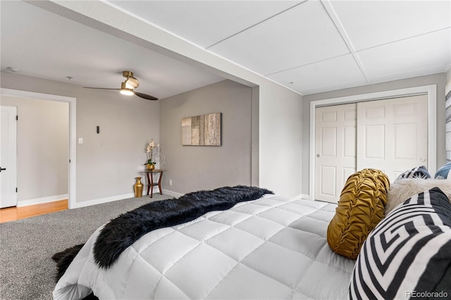 bedroom with ceiling fan, baseboards, a closet, and light carpet