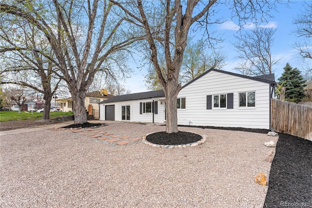 view of front of property featuring a garage and fence