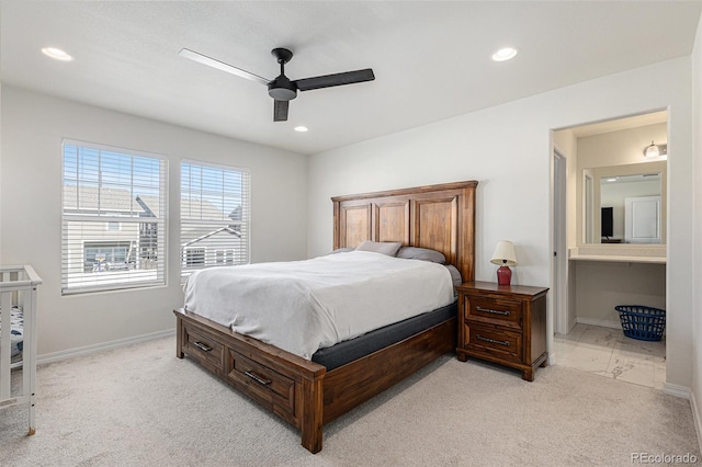 bedroom with light carpet, ensuite bathroom, and ceiling fan