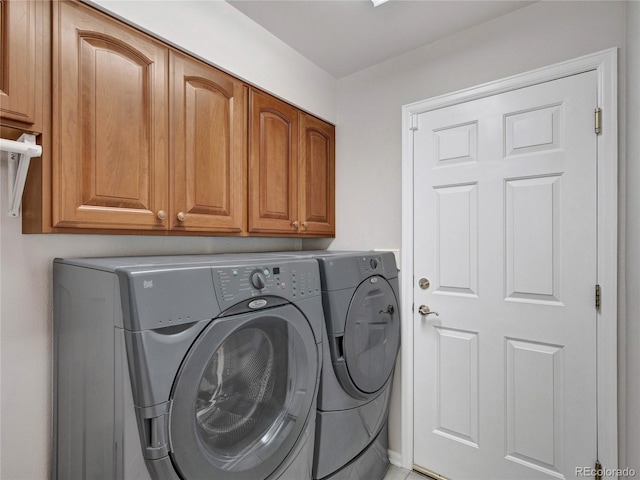 laundry area with washing machine and dryer and cabinets