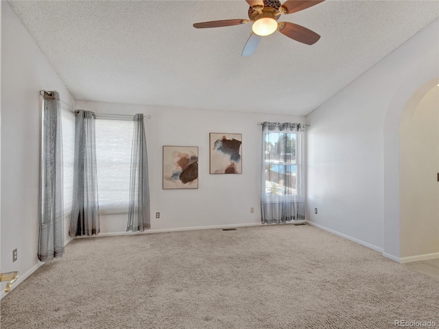 unfurnished room with a textured ceiling, ceiling fan, light carpet, and lofted ceiling