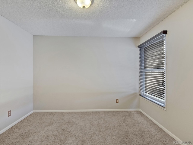 carpeted empty room featuring a textured ceiling