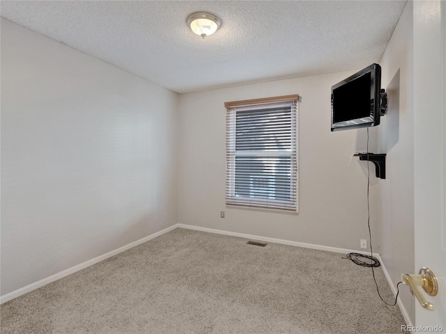 unfurnished room featuring carpet flooring and a textured ceiling