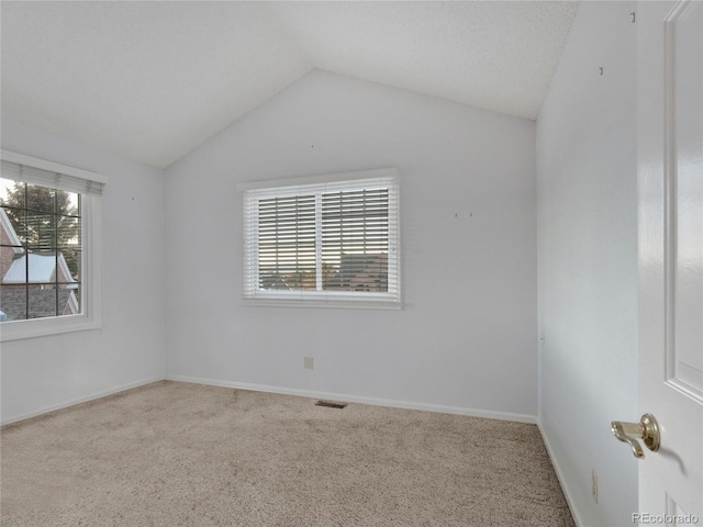 spare room with carpet floors and vaulted ceiling