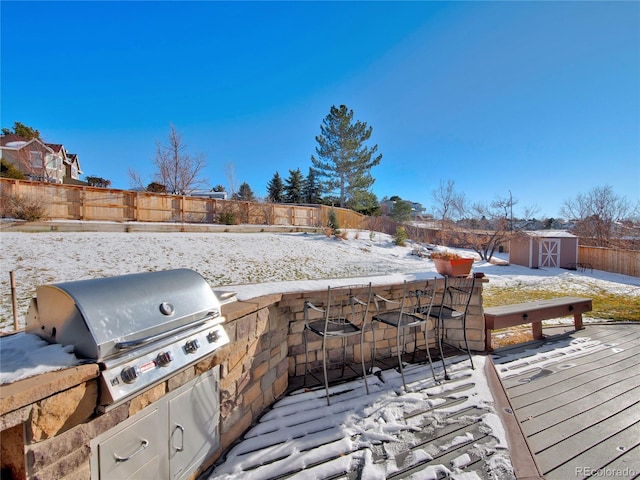 snow covered deck with a bar and a grill