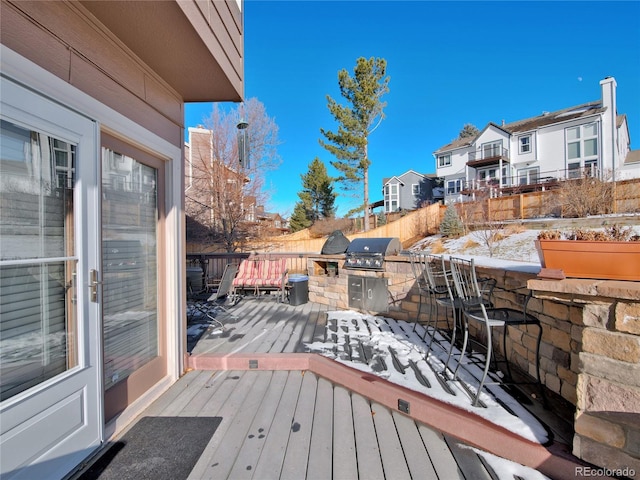 wooden deck with a grill, a bar, and an outdoor kitchen