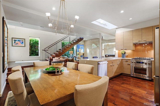 dining room featuring stairs, recessed lighting, a skylight, a notable chandelier, and dark wood-style flooring