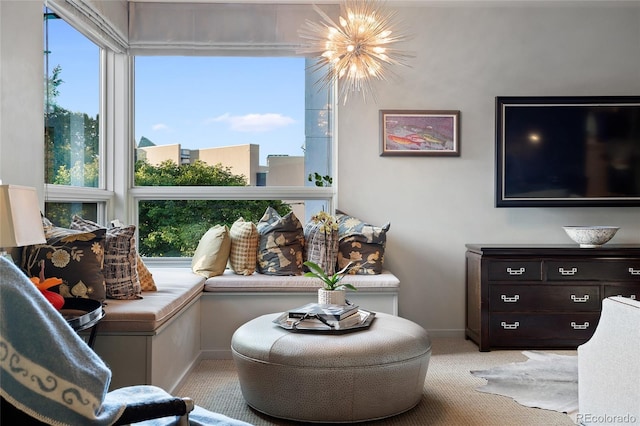 sitting room featuring baseboards, light carpet, and a notable chandelier