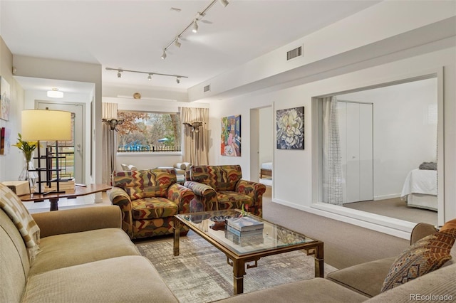 living room featuring visible vents, baseboards, and carpet