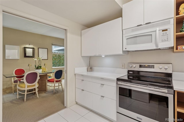 kitchen featuring white cabinetry, white microwave, light countertops, and electric stove