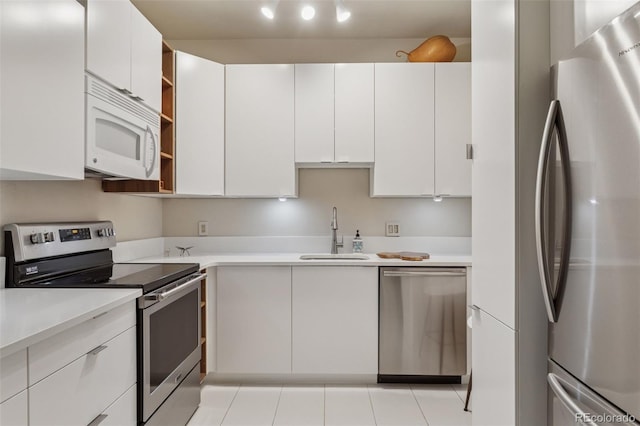 kitchen featuring a sink, open shelves, white cabinetry, stainless steel appliances, and light countertops