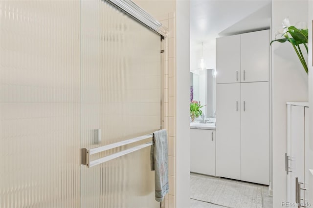 interior space featuring vanity, tile patterned floors, and a shower with door