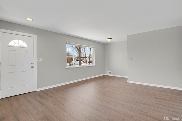 entryway with wood finished floors, visible vents, and baseboards