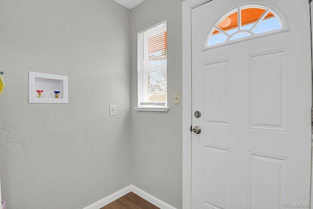 interior space with dark wood-style floors, baseboards, hookup for a washing machine, and laundry area