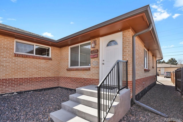 doorway to property featuring brick siding