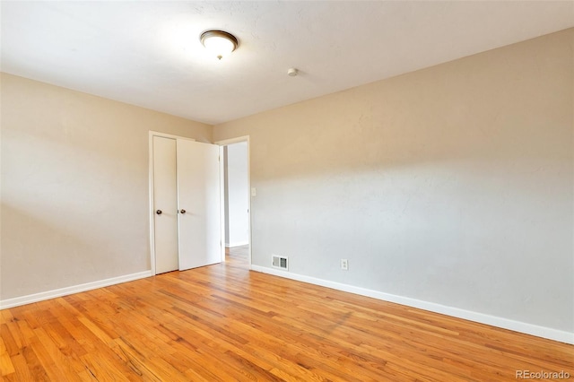 empty room with visible vents, baseboards, and light wood-style floors