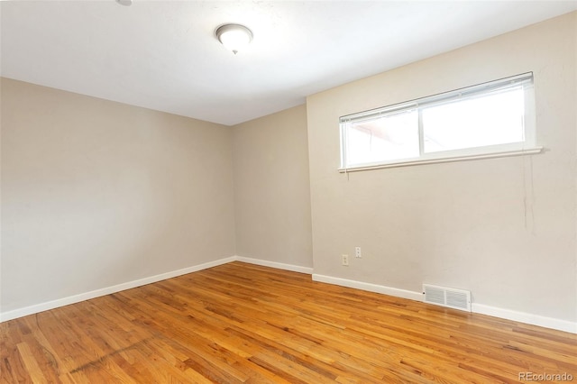 unfurnished room featuring visible vents, baseboards, and light wood-style floors