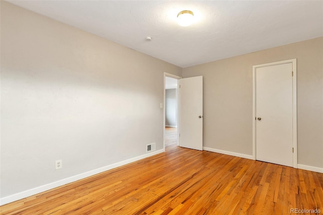 unfurnished bedroom with visible vents, baseboards, and wood finished floors