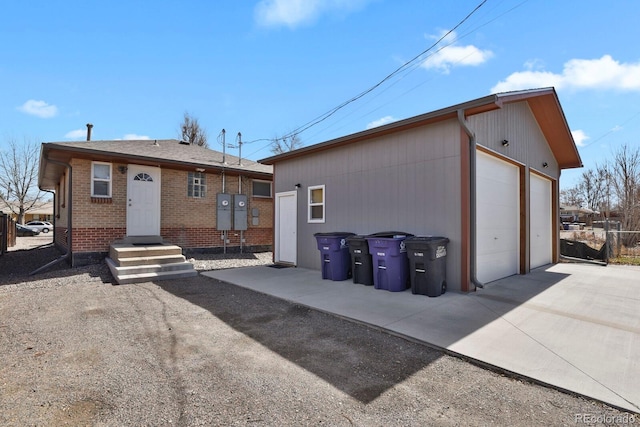 view of front of property with an outbuilding, a detached garage, and brick siding