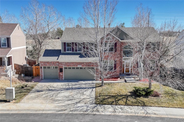 traditional home with driveway, brick siding, roof with shingles, and fence