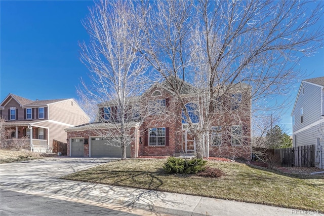 traditional home featuring brick siding, fence, driveway, and a front lawn