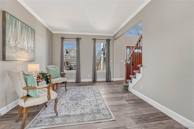 sitting room featuring crown molding, baseboards, and wood finished floors