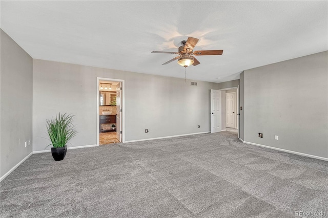 carpeted spare room featuring baseboards, a textured ceiling, visible vents, and a ceiling fan