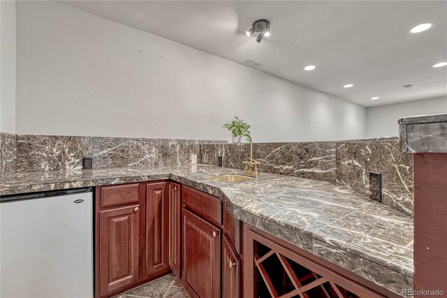 kitchen with tile countertops, recessed lighting, refrigerator, a sink, and visible vents