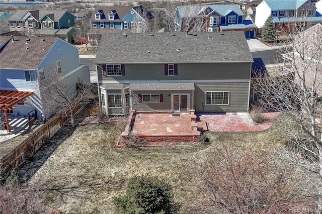 rear view of property with a patio, roof with shingles, and a residential view