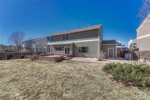 back of property with a patio area, a fenced backyard, and a yard