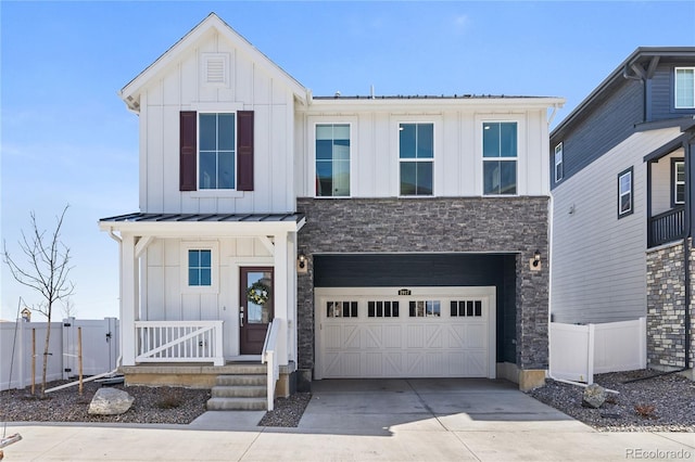 modern farmhouse with concrete driveway, board and batten siding, a garage, and fence