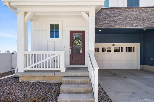 entrance to property with concrete driveway, board and batten siding, and an attached garage