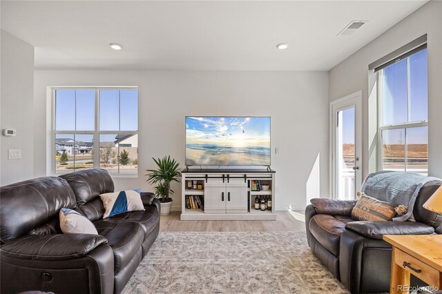 living room featuring visible vents, light wood-style flooring, baseboards, and recessed lighting