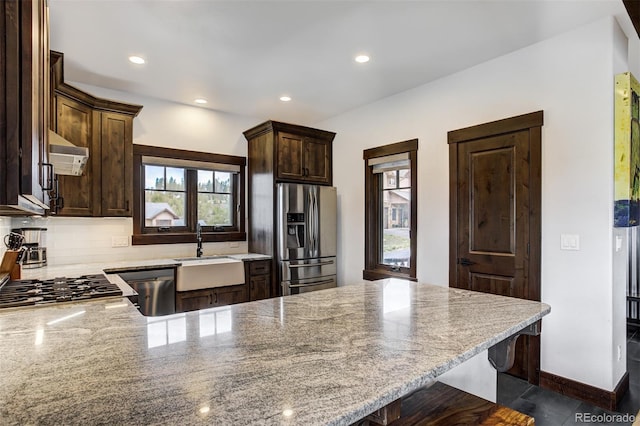 200 Quill, Fraser, CO 80442 - kitchen with stainless steel appliances, a sink, dark brown cabinets, light stone counters, and a peninsula