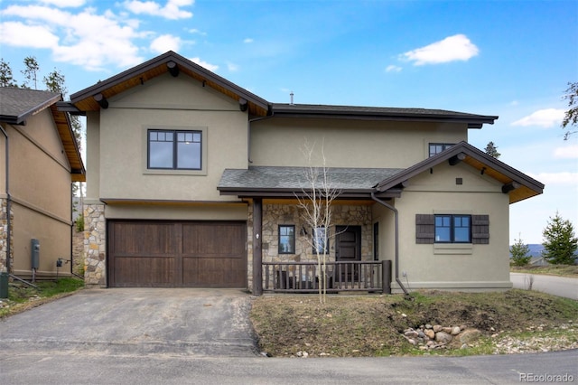 200 Quill, Fraser, CO 80442 - view of front of house with stucco siding, stone siding, driveway, a garage, and a porch