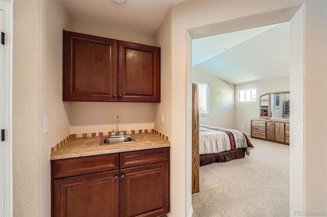 bedroom featuring light carpet, wet bar, and a sink