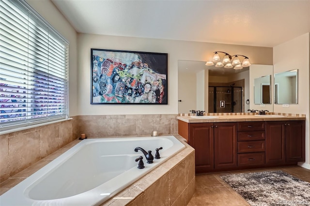 bathroom with a garden tub, a sink, an inviting chandelier, a shower stall, and double vanity