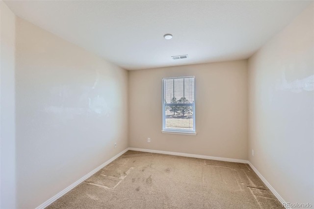 unfurnished room with light colored carpet, visible vents, and baseboards