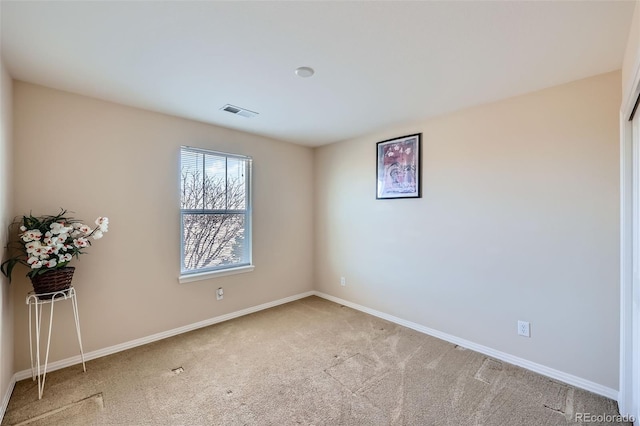 empty room featuring carpet, visible vents, and baseboards